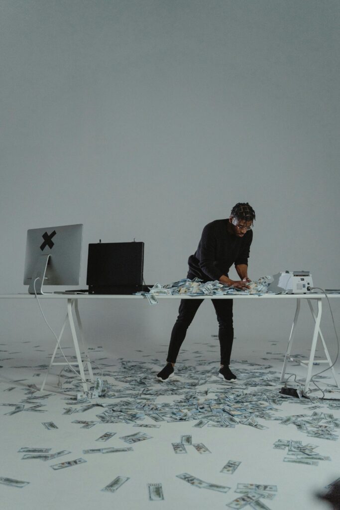Businessman counting large sum of money on a desk, conveying themes of wealth and finance.